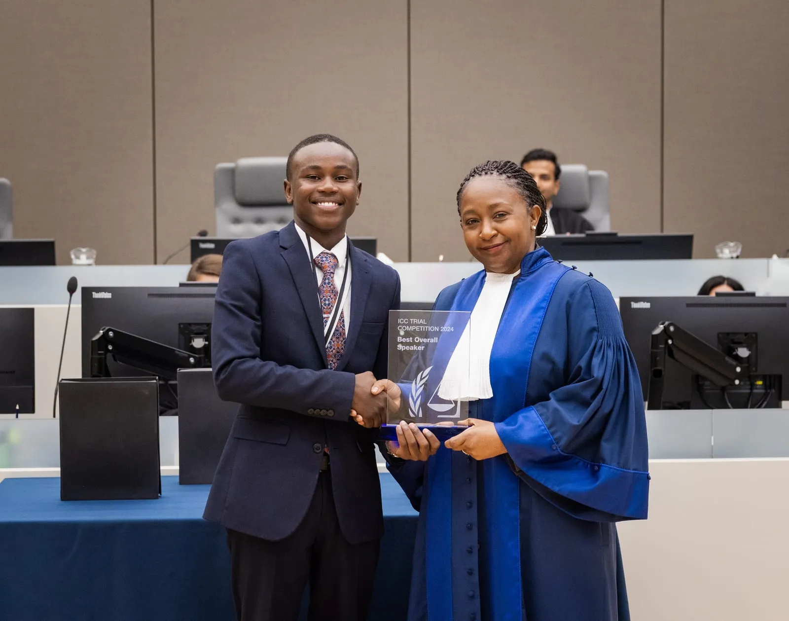 A competitor receiving the Best Overall Speaker award from a judge at the 2024 ICC Moot Court Competition Final